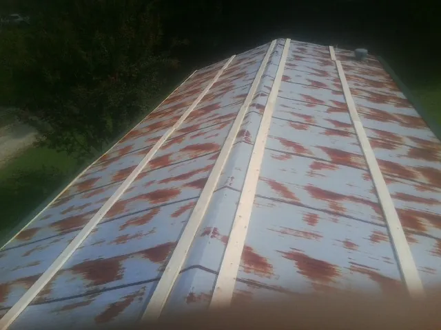 Rusted metal roof panels with new wood purlins before replacement — Storm Damage Roof Repair in Des Moines by Roofing Brothers