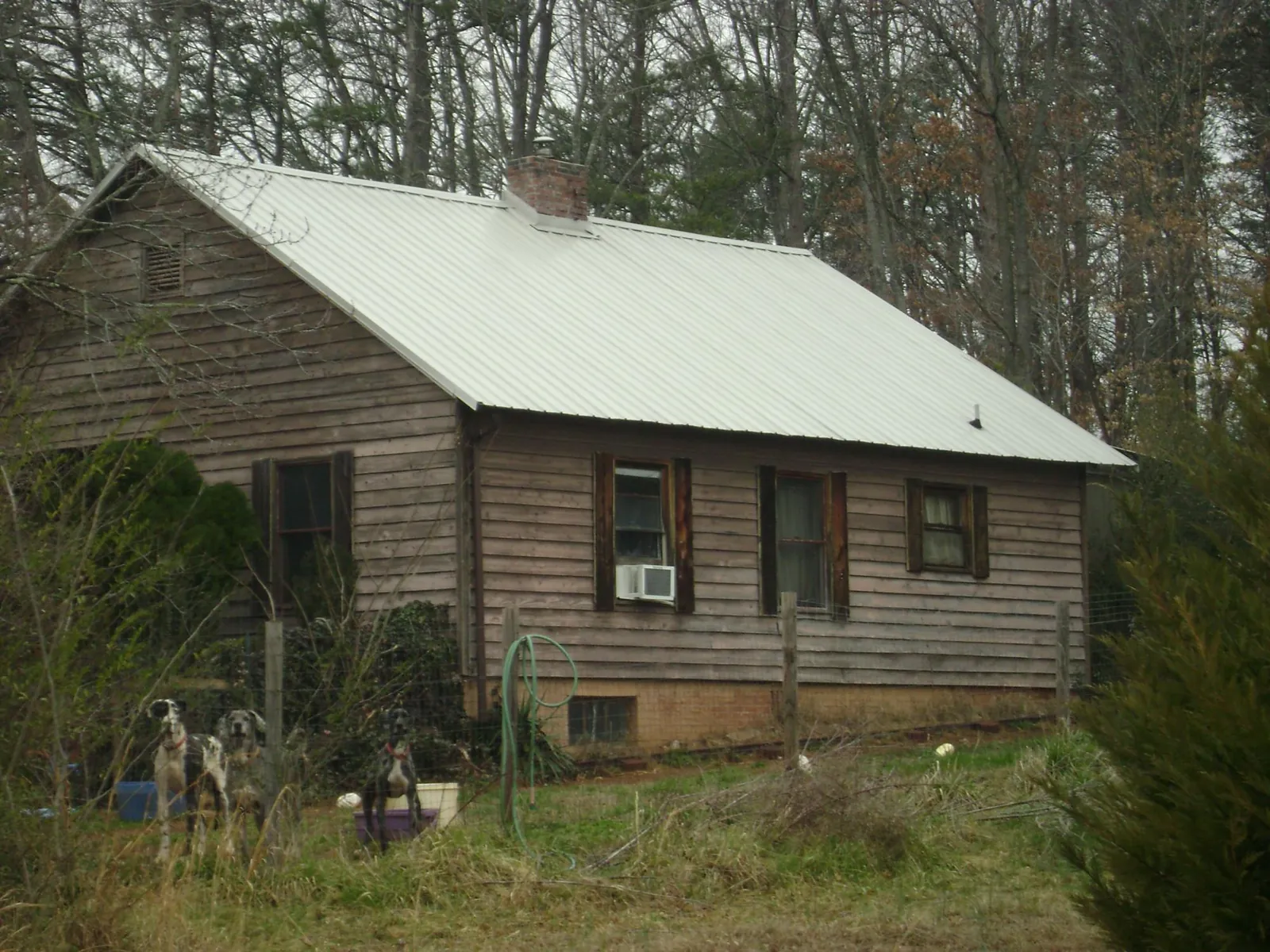 White metal roof on an old wood sided farmhouse, from a Metal Roof Installation job in Des Moines